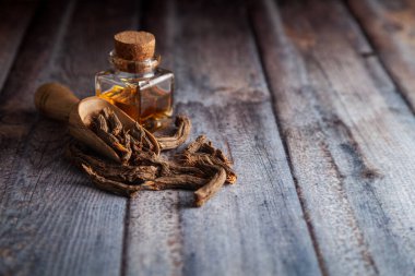 Kuru organik Sugandh Mantri (Homalomena aromatica), temel yağıyla birlikte ahşap bir kepçeyle.