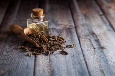 Kuru organik Sugandha Bala (Pavonia Kodorata) kökleri, temel yağ kepçesiyle birlikte ahşap bir kepçenin içinde.