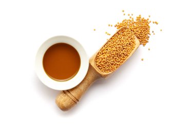 Kuru organik hardal tohumlarının (Sinapis alba) en üst görüntüsü, temel yağ kepçesiyle birlikte ahşap bir kepçeyle.