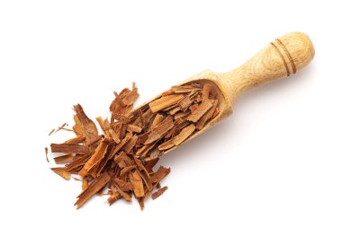 Tahta bir kepçeyle organik tarçın çubuklarının (Tarçın verum) en üst görüntüsü. Beyaz bir arkaplanda izole edilmiş.