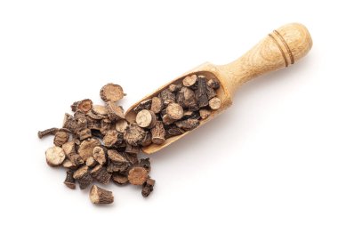 Organik Altın Göz Çimeni veya Siyah Musli (Curculigo orchioides) bitkisiyle dolu ahşap bir kepçenin üst görüntüsü. Beyaz bir arkaplanda izole edilmiş.