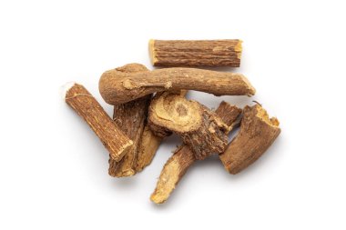 Beyaz arka planda izole edilmiş bir yığın kuru organik meyan kökü (Glicyrhiza glabra). Üst görünüm