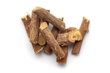 Beyaz arka planda izole edilmiş bir yığın kuru organik meyan kökü (Glicyrhiza glabra). Üst görünüm