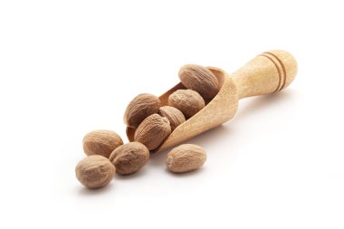 Organik Nutmeg tohumu (Myristica parfümleri) ile dolu tahta bir kepçenin ön görüntüsü. Beyaz bir arkaplanda izole edilmiş.