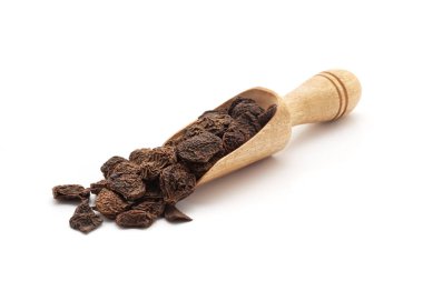 Organik Shikakai (Acacia concinna) meyveleriyle dolu ahşap bir kepçenin önü. Beyaz bir arkaplanda izole edilmiş.