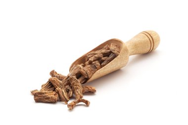 Organik Tatlı Bayrak veya Vach (Acoru scalamus) kökleriyle dolu ahşap bir kepçenin ön görüntüsü. Beyaz bir arkaplanda izole edilmiş.