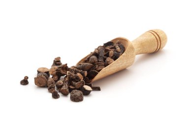 Organik altın göz çimeni veya Siyah Musli (Curculigo orchioides) bitkisiyle dolu ahşap bir kepçenin ön görüntüsü. Beyaz bir arkaplanda izole edilmiş.