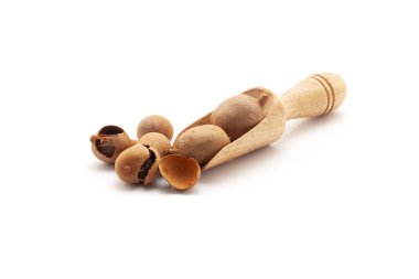 Taze Organik Tatlı Tamarind (Tamarindus indica) Frruit ile dolu ahşap bir kepçenin ön görüntüsü. Beyaz bir arkaplanda izole edilmiş.