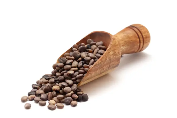 stock image Front view of a wooden scoop filled with dry Organic cluster bean  (Cyamopsis tetragonoloba) seeds. Isolated on a white background.