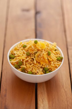 Mısır gevreği karışımı Hindistan çerezi (abur cubur), Hint tuzlu atıştırmalıkları (Namkeen), ahşap arka planda beyaz seramik kasede