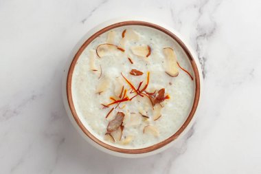 Safran ve kuru meyvelerle süslenmiş kremalı Sabudana Kheer 'in yakın çekimi. Hint usulü lezzetli tatlı. Seramik kasede servis edilir.. 