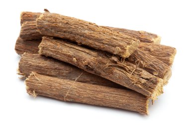 Beyaz arkaplanda izole edilmiş kuru meyan kökleri (Glycyrrhiza glabra) kökleri yakın plan.