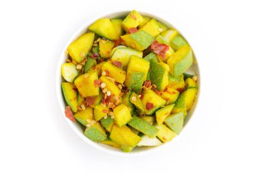 Mangifera indica (Mangifera indica) dilimlenmiş organik Hint mangosu, beyaz kâse içinde zerdeçal, tuz ve kırmızı biber ile tatlandırılmıştır. Beyaz arka planda izole edilmiş. Üst manzara..