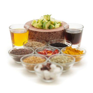 Hindistan mango turşusu için ham malzemeler beyaz arka planda izole edilmiş cam kaselerde.. 