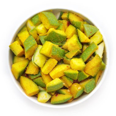 Mangifera indica (Mangifera indica), beyaz kasede zerdeçal tozu ve tuz ile tatlandırılmış organik Hint mangosu. Beyaz arka planda izole edilmiş. Üst görünüm.