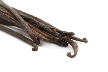 Beyaz arka planda izole edilmiş organik kuru vanilya çubukları (vanilya planifolia). Makro, kapat. Üst görünüm.
