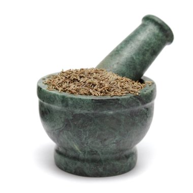 Organic Cumin seed (Cuminum cyminum) on marble pestle. Isolated on white background. clipart