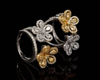 Güzel elmas yüzüğe yakın, siyah arka planda bir sürü değerli Gemstone var.