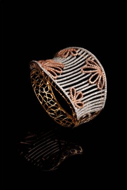 Tasarımcı elmas bilezik. Arka planda birçok taş var.