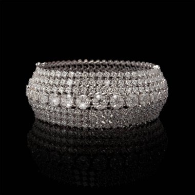 Tasarımcı elmas bilezik. Arka planda birçok taş var.