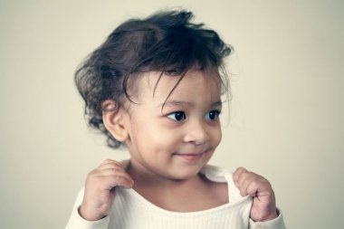 Gri arka planda oynayan sevimli Hintli bebek..