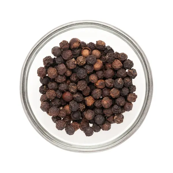 Stock image Top view of Organic Black pepper (Piper nigrum) half filled in glass bowl isolated on white background.