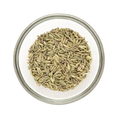 Organik rezene tohumu üst görünümü (Foeniculum vulgare) yarım cam kase beyaz arka planda izole dolu.