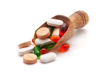 Health care concept. A wooden scoop filled With different Medical Tablets, Pills, and Capsules. Isolated on a white background. clipart