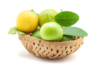 A wooden basket filled with fresh green organic lemons (Citrus limon) with leaves. Isolated on a white background. Front view. clipart