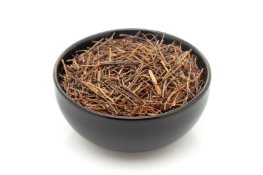 Kuru Organik Amar Bel (Cuscuta reflexa) köklerine yakın plan, siyah seramik kasede. Beyaz bir arkaplanda izole edilmiş.