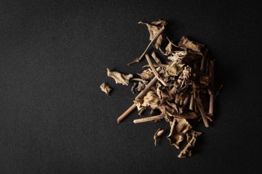 A pile of Dry Organic Punarnava (Boerhavia diffusa) roots and leaves, isolated on a black background. Top view clipart