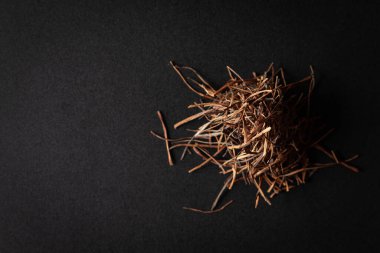 Bir yığın kuru organik Amar Bel (Cuscuta reflexa) kökü, siyah arka planda izole edilmiştir. Üst görünüm