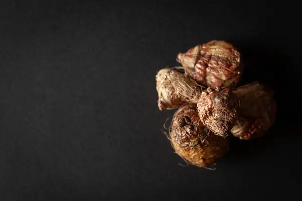 stock image A pile of Dry Organic Liquorice or Mulethi (Glycyrrhiza glabra), isolated on a black background. Top view