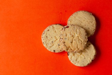 Turuncu arka planda bütün buğday cipsi kurabiyelerini yığdım. Tepeden tırnağa. Besin düzlüğü.