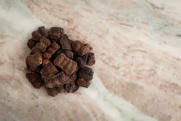 stock image A pile of Dry Organic Shikakai (Acacia concinna) fruits, on a marble background. Top view