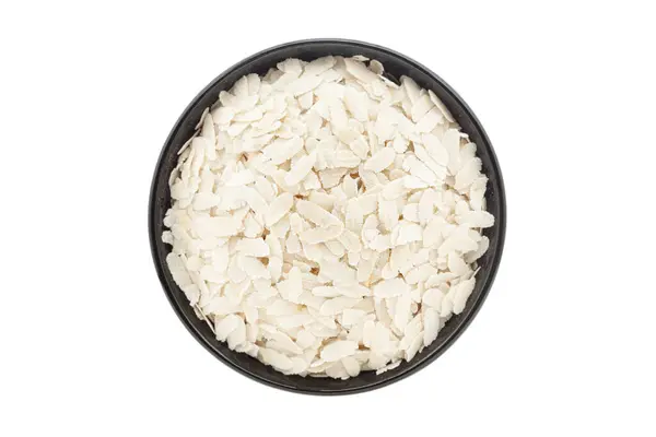 stock image Organic Flattened Rice (Oryza Sativa) or Poha, in a black ceramic bowl. Isolated on a white background. Top View