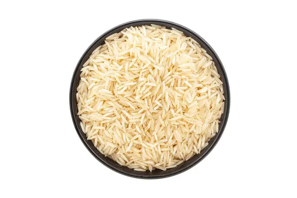 Siyah bir seramik kasede organik beyaz pirinç (Oryza sativa) bulunur. Beyaz bir arka planda izole edilmiş. Üst Görünüm