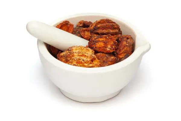 stock image Close-up of Dry Organic Stone Apple or Bel (Aegle marmelos) fruit, in white ceramic mortar and pestle, isolated on a white background.