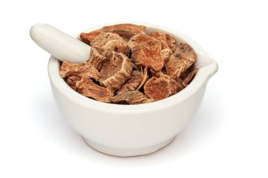 Beyaz seramik havan ve tokmak içinde kuru organik Semal Musli (Bombax Mulabaricum) bitkisine yakın plan, beyaz zemin üzerinde izole.