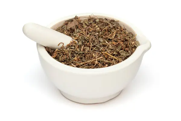 stock image Close-up of Dry Organic Wood Violet or Banafsha (Viola odorata) herb, in white ceramic mortar and pestle, isolated on a white background.