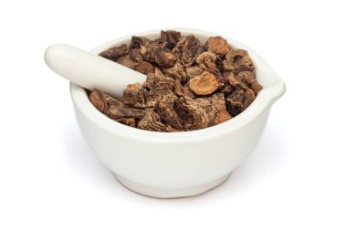 Beyaz bir zemin üzerinde izole edilmiş seramik havan ve tokmak, Kuru Organik Kırmızı Bilge veya Behman Lal (Salvia Haematodes) bitkisi yakın plan.