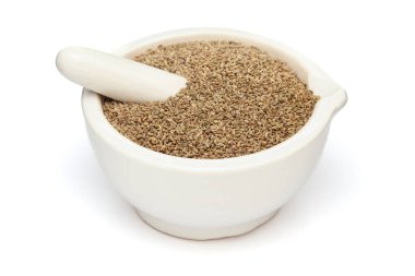 Close-up of Dry Organic Carom seeds (Trachyspermum ammi) or Ajwain, in white ceramic mortar and pestle, isolated on a white background. clipart