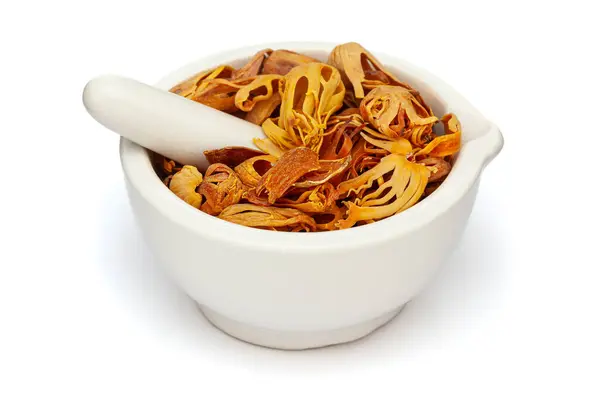 stock image Close-up of Dry Organic Mace (Myristica fragrans) or javitri, in white ceramic mortar and pestle, isolated on a white background.