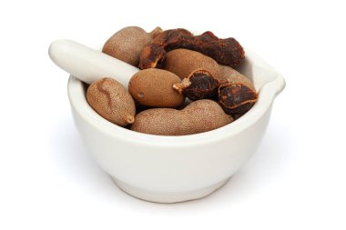 Close-up of fresh Organic Sweet Tamarind (Tamarindus indica) Fruit, in white ceramic mortar and pestle, isolated on a white background. clipart