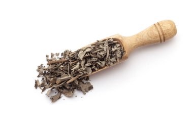 Kuru organik Nirgundi (Vitex negundo) yapraklarıyla dolu tahta bir kepçenin üst görüntüsü. Beyaz bir arkaplanda izole edilmiş.