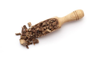 Kuru organik Gulvel veya Giloy (Tinospora cordifolia) otuyla dolu ahşap bir kepçenin üst görüntüsü (Kalp terk edilmiş ay tohumu, guduchi, giloy, crispa). Beyaz bir arkaplanda izole edilmiş.