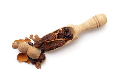 Taze Organik Tatlı Tamarind (Tamarindus indica) ile dolu ahşap bir kepçenin üst görüntüsü. Beyaz bir arkaplanda izole edilmiş.