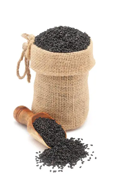 stock image Close-up of Organic Black Sesame (Sesamum indicum) Seeds, in a jute bag and on a scoop, Isolated on a white background.