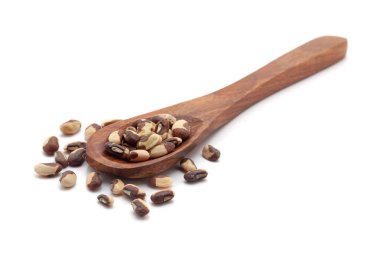 Kuru organik fasülye veya Black Eyed Peas (Vigna unguiculata) tohumlarıyla dolu bir tahta kaşığın ön görüntüsü. Beyaz bir arkaplanda izole edilmiş.