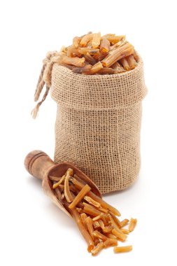 Kuru Organik Shatavari (Asparagus racemosus) kökleri yakın plan, bir jute çanta ve bir kepçe üzerinde, beyaz bir arka plan izole.